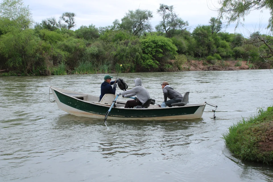 Participantes y cañas a bordo del bote.