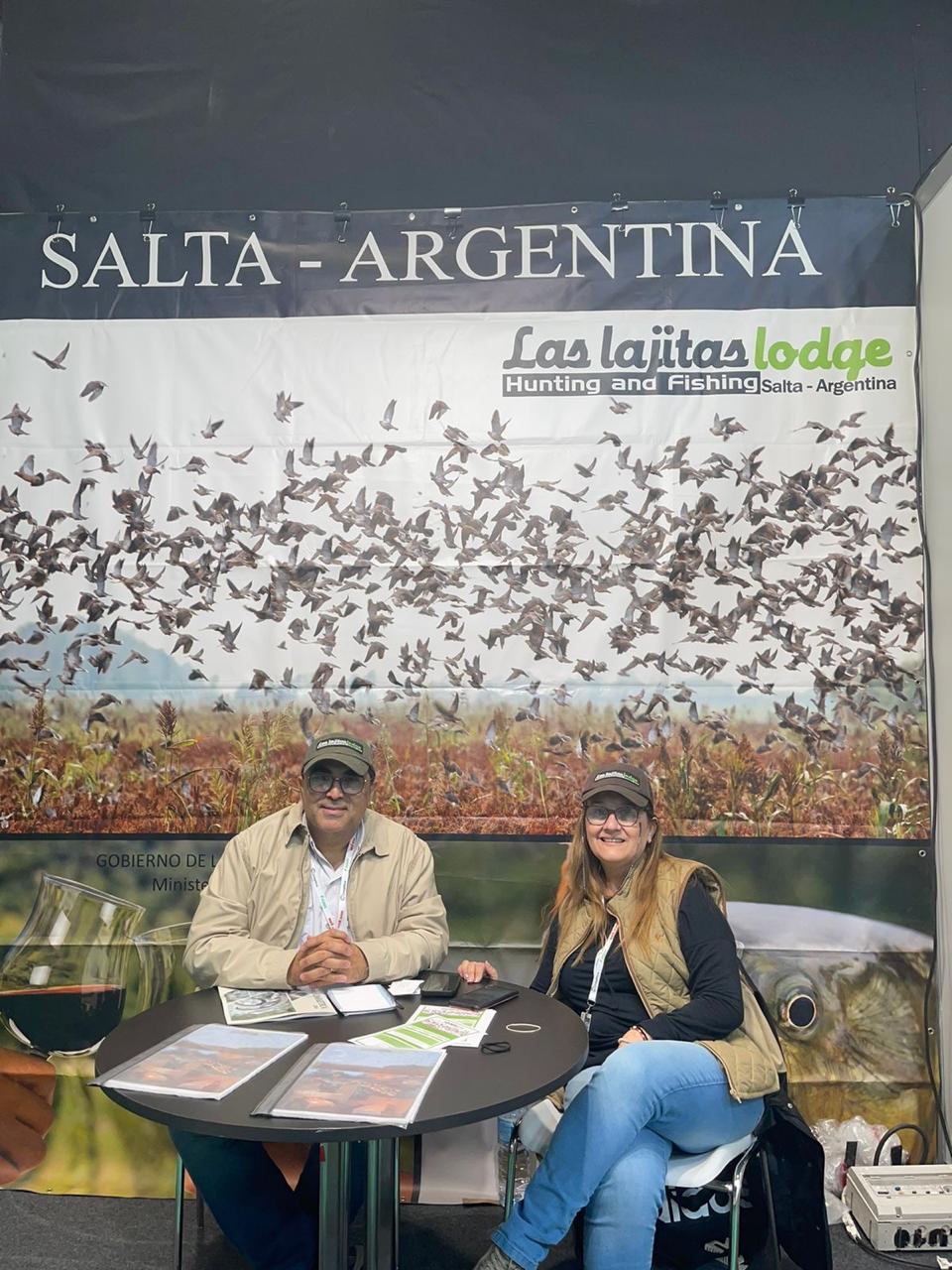Carlos y Patricia sentados en un stand de caza y pesca.